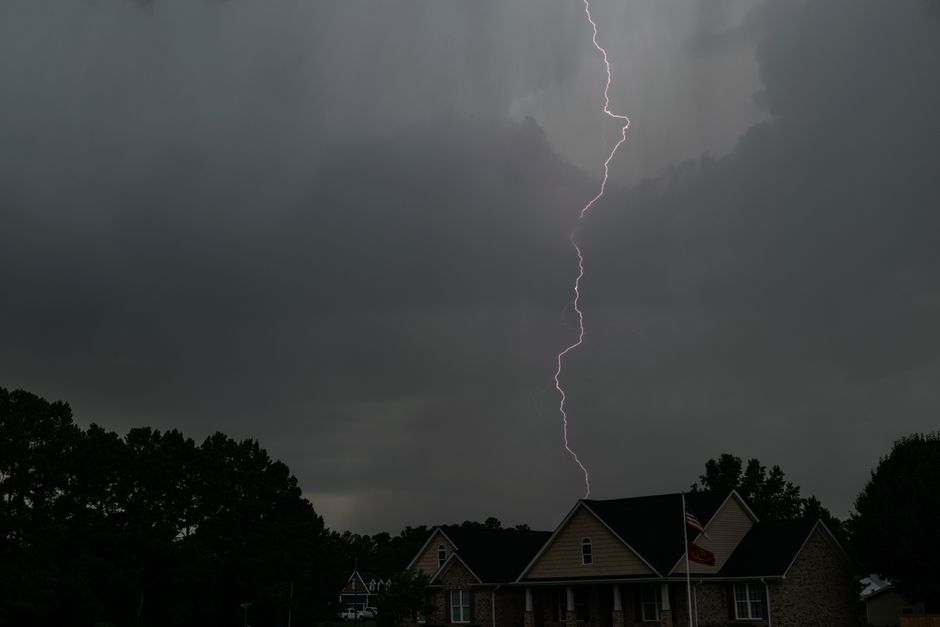 A striking lightning bolt pierces the stormy sky over suburban houses in North Carolina.